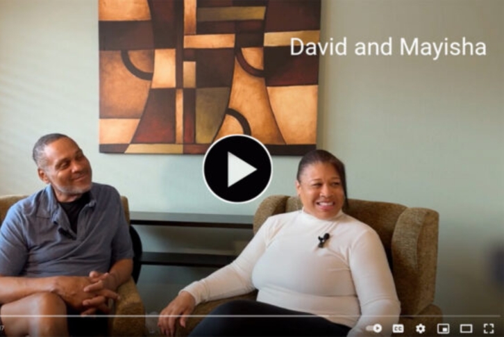 A video thumbnail of a couple smiling sitting on the couch, with the text David and Mayisha