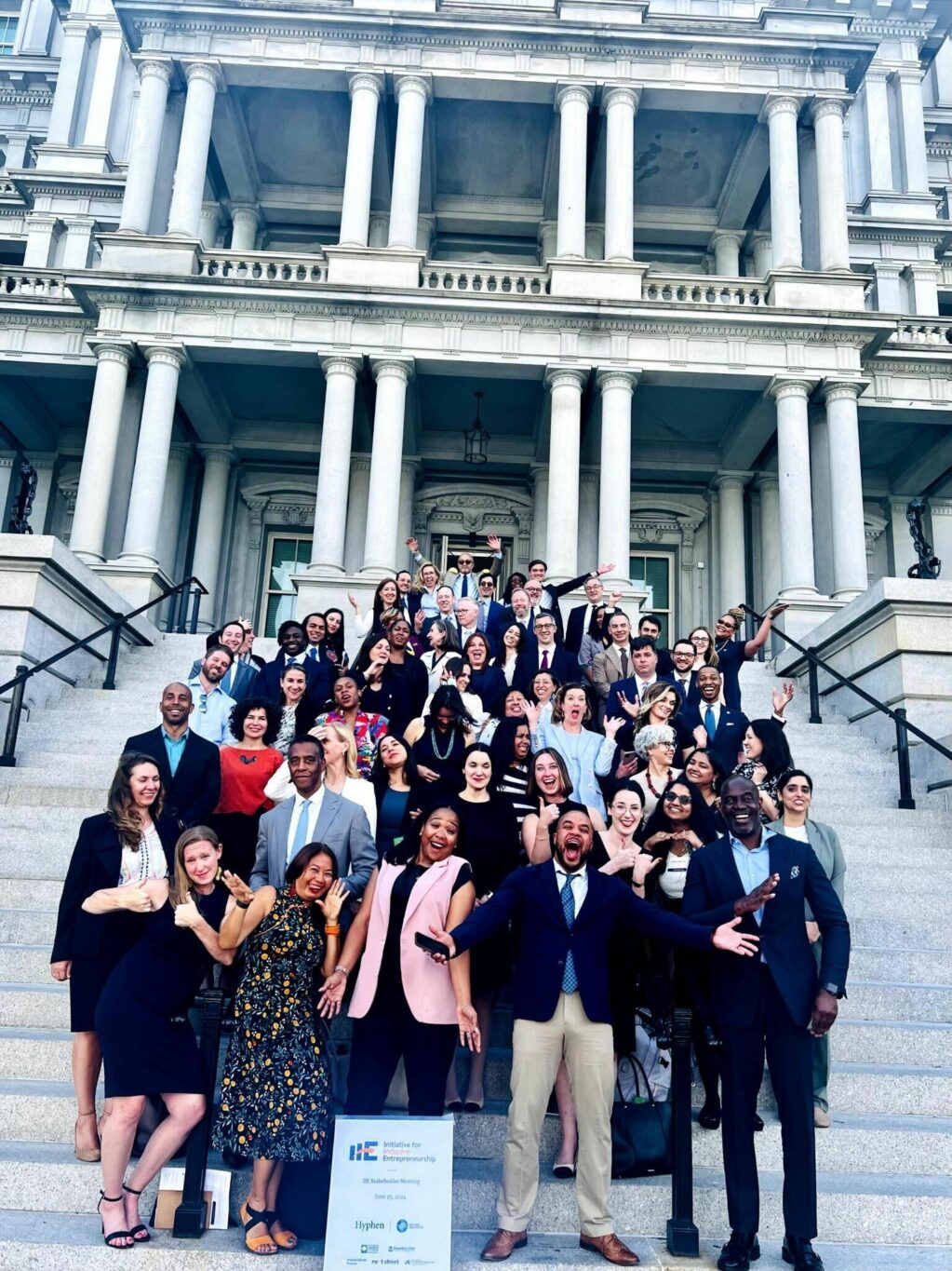 A group of people pose on the steps of a building