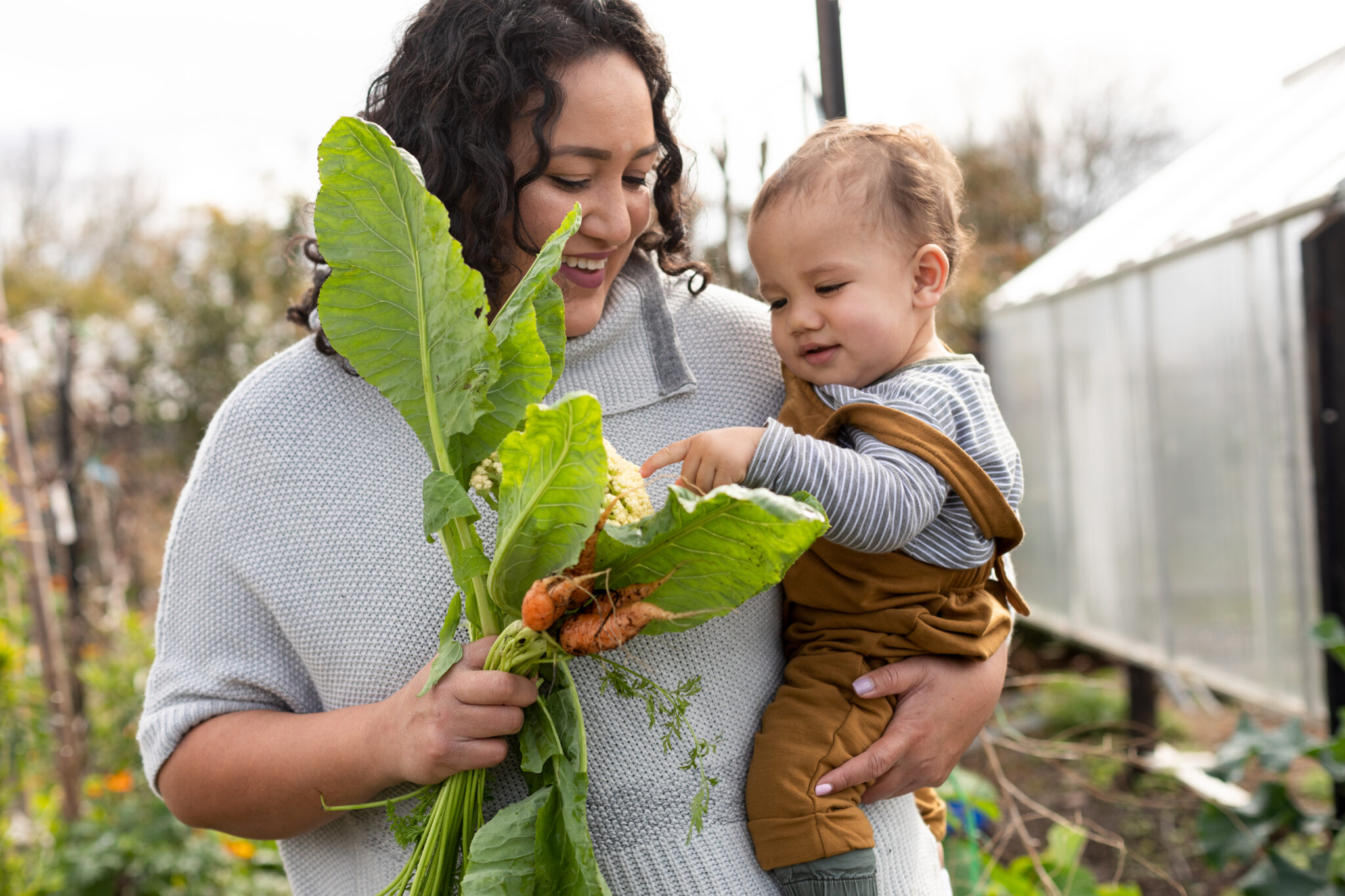 A mother and child holding some vegetables